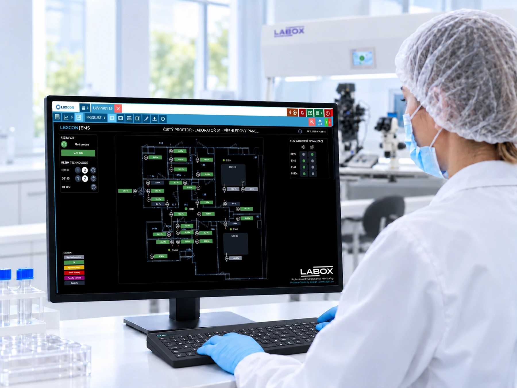 Obsluha laboratoře sleduje panel LBXCON EMS, v pozad&iacute; lamin&aacute;rn&iacute; box LABOX